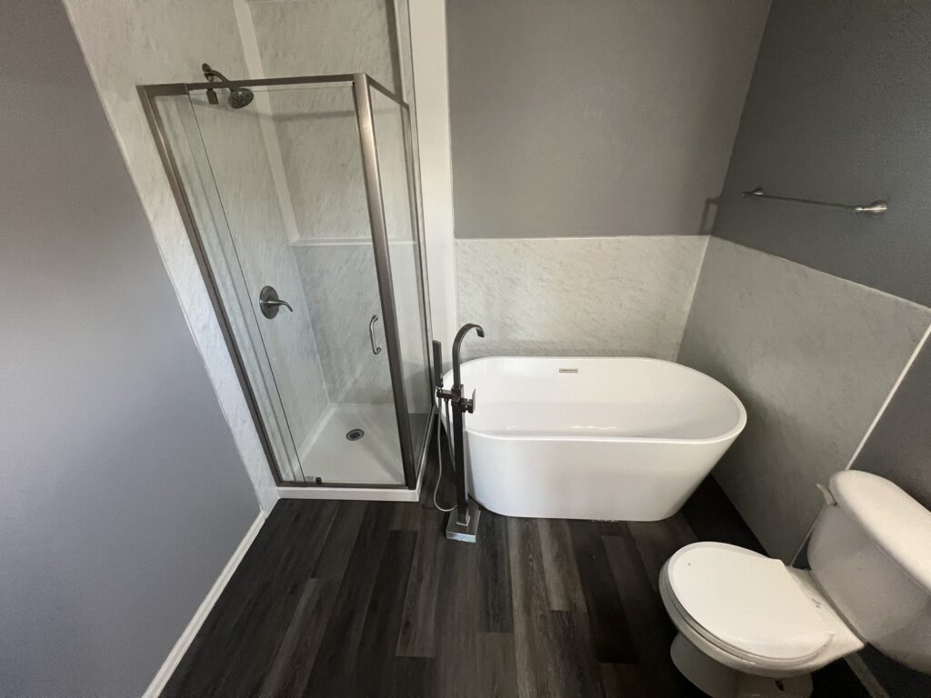 Completed spa-style bathroom remodel with grout-free solid-surface panels and soaking tub